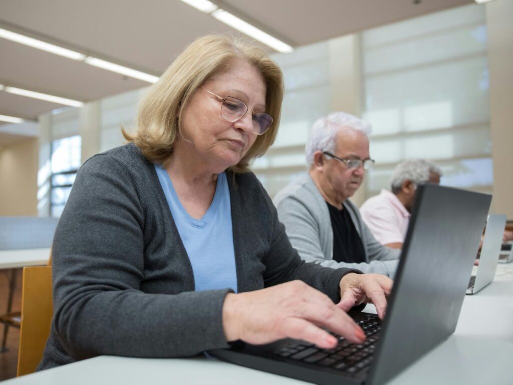 senior citizens working on laptops