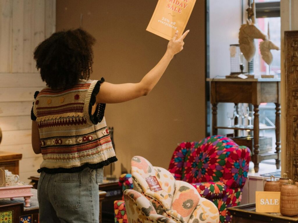 woman putting up a sale sign