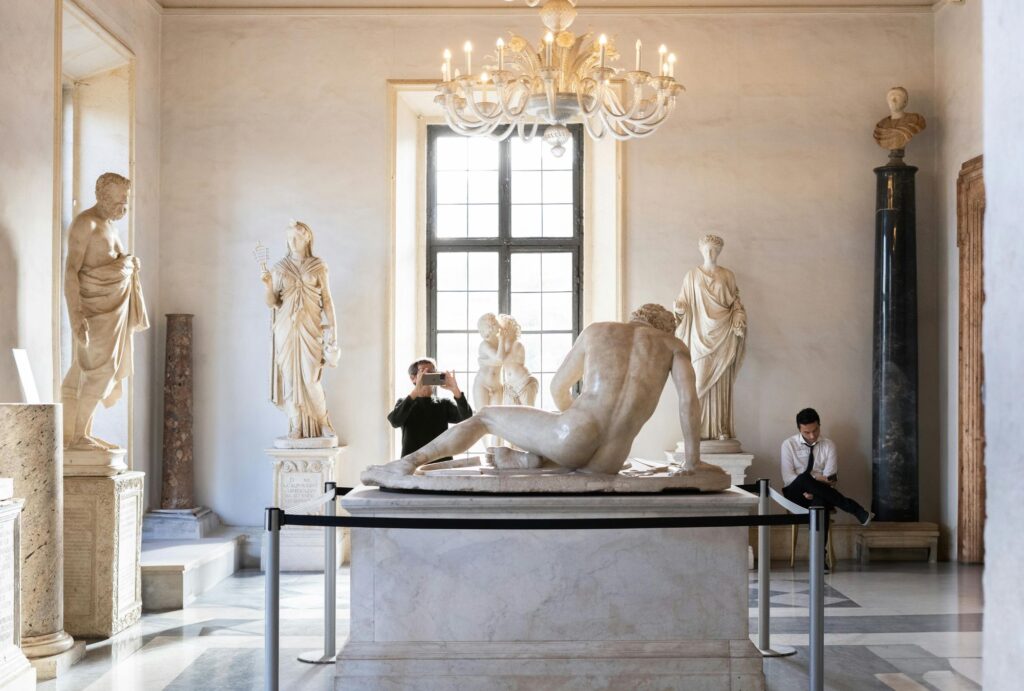 man clicking photo of sculpture in museum