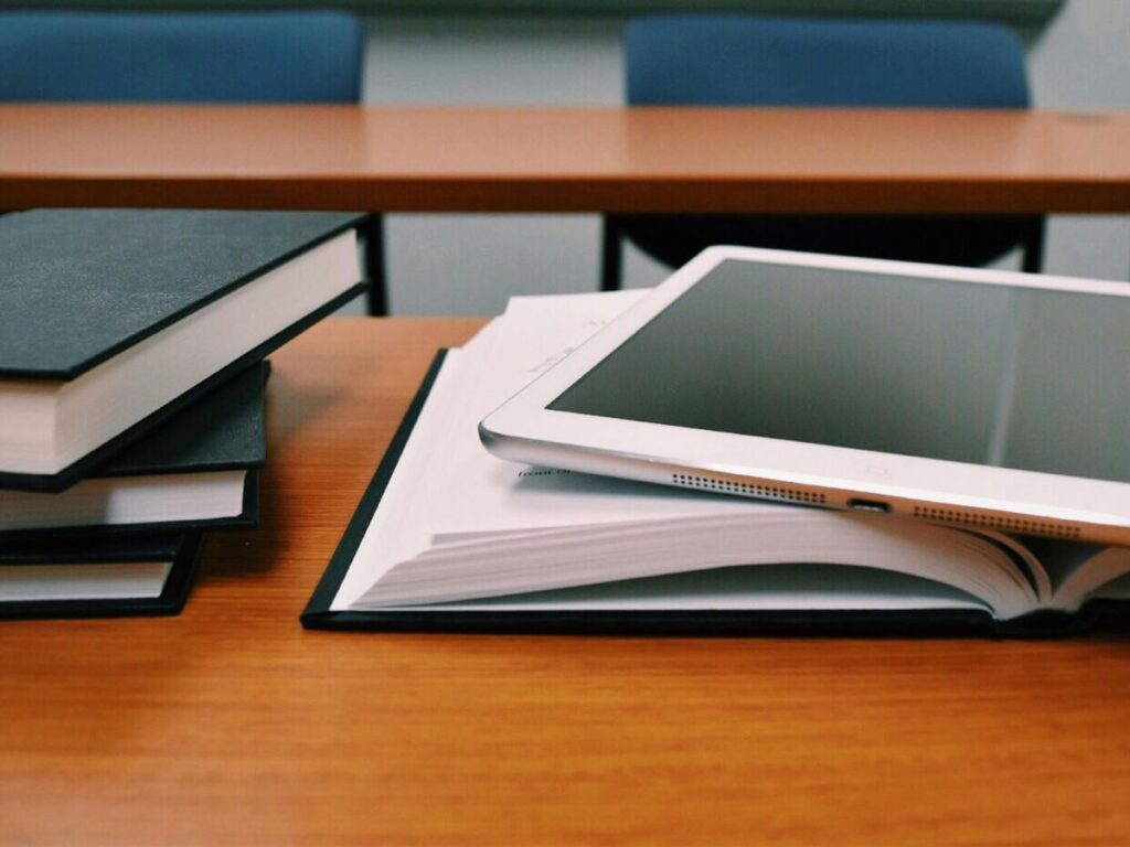 books and tablet on a table in a classroom