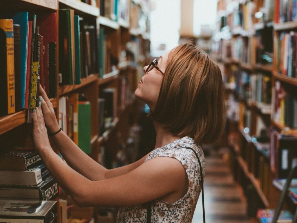 woman looking for a book in a library