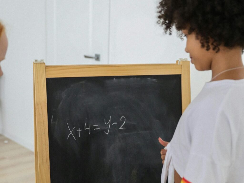 kid writing on a blackboard