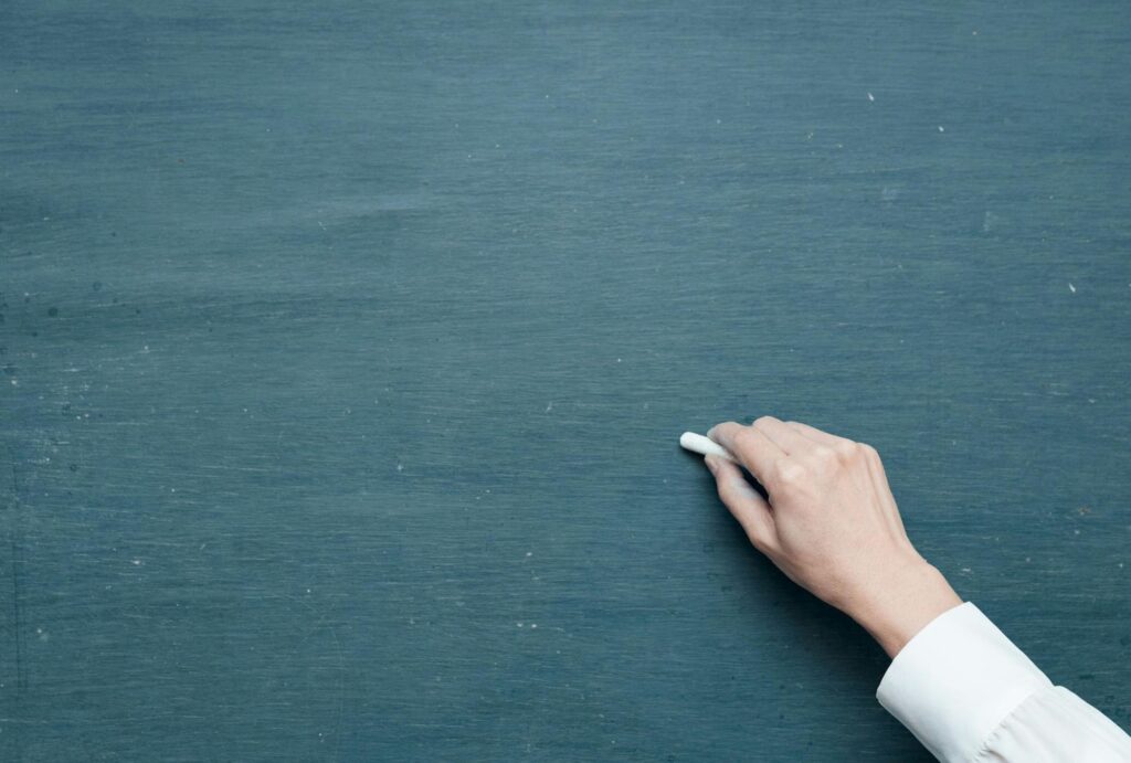 teacher writing on blackboard