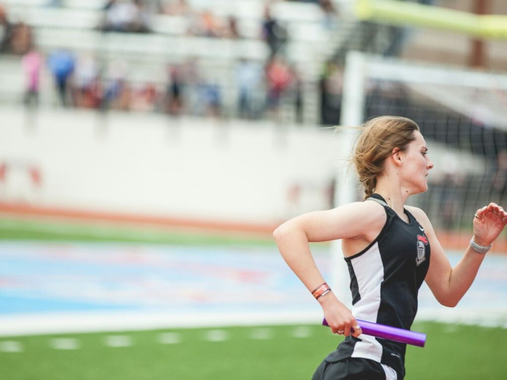 woman running a relay race