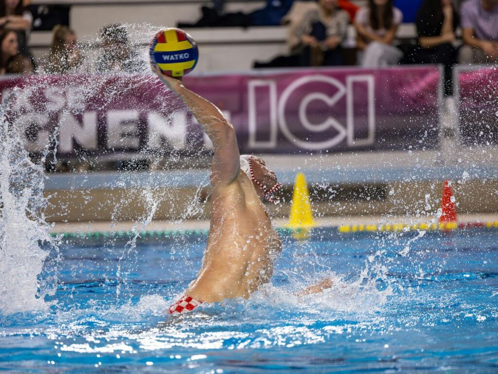 man swimming and playing with ball