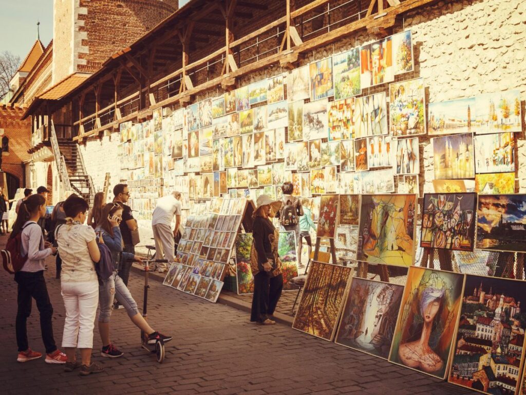 people looking at paintings on road