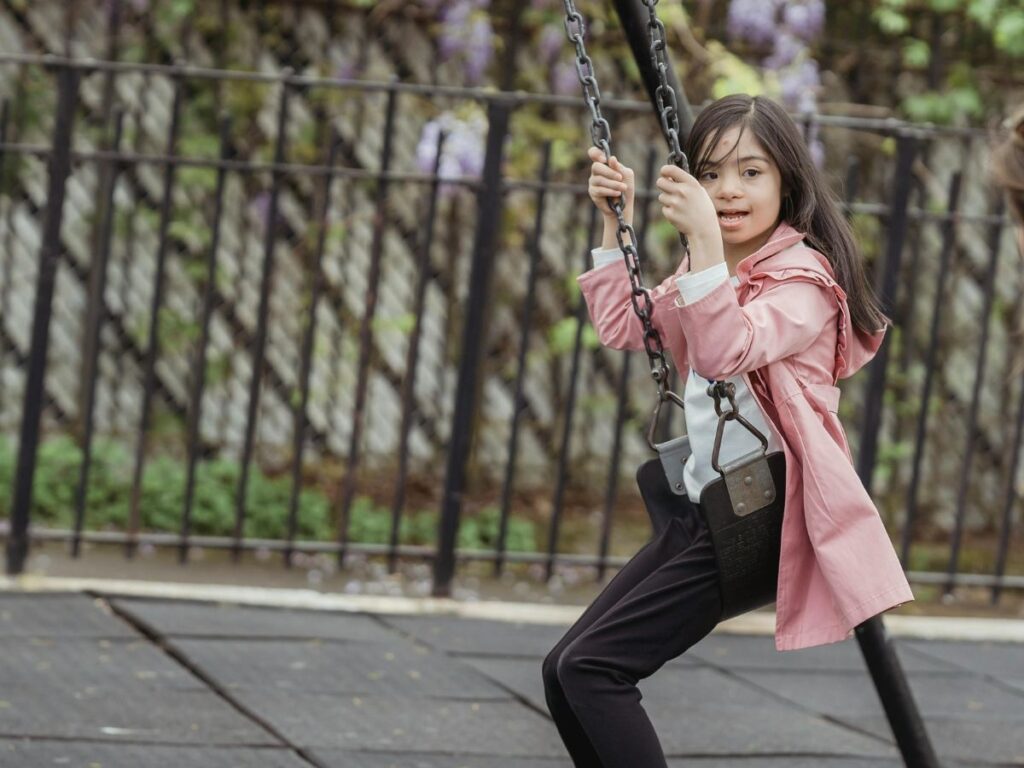 young girls taking a swing in a park