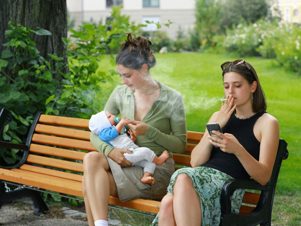 women sitting in a park with a baby