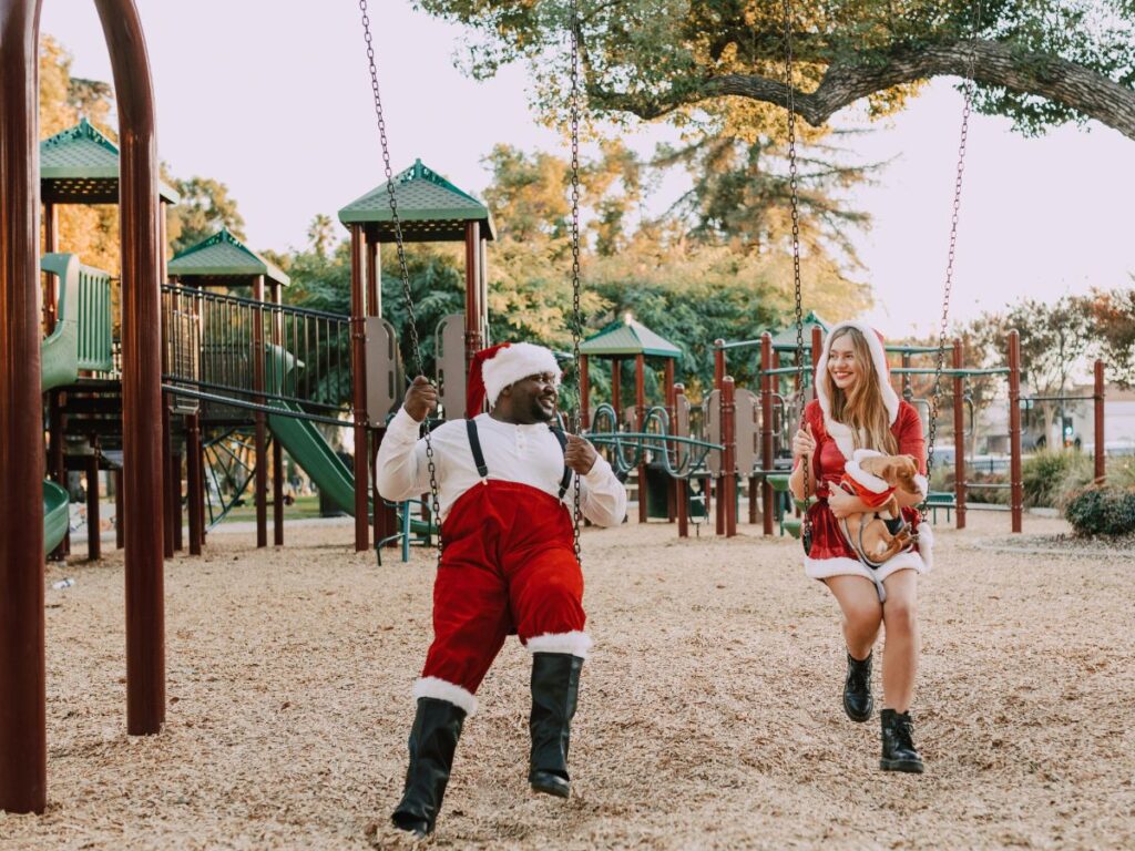 man and woman enjoying Christmas on swings